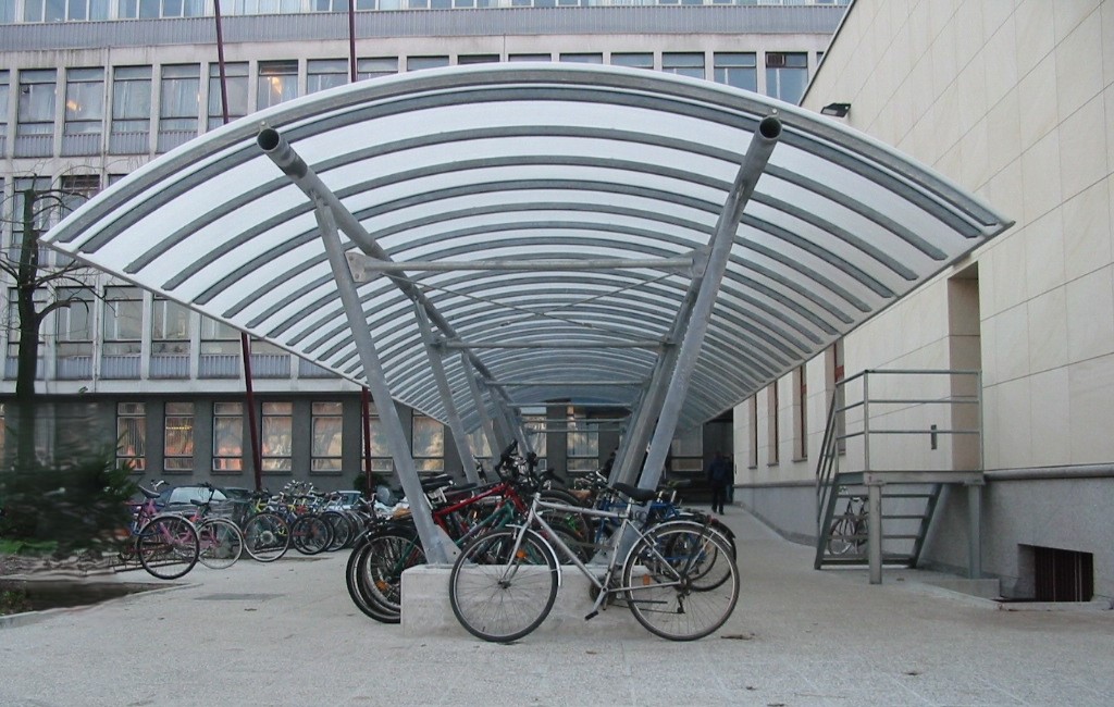 Jekleni nadstrešek za kolesa z ukrivljeno strešno konstrukcijo